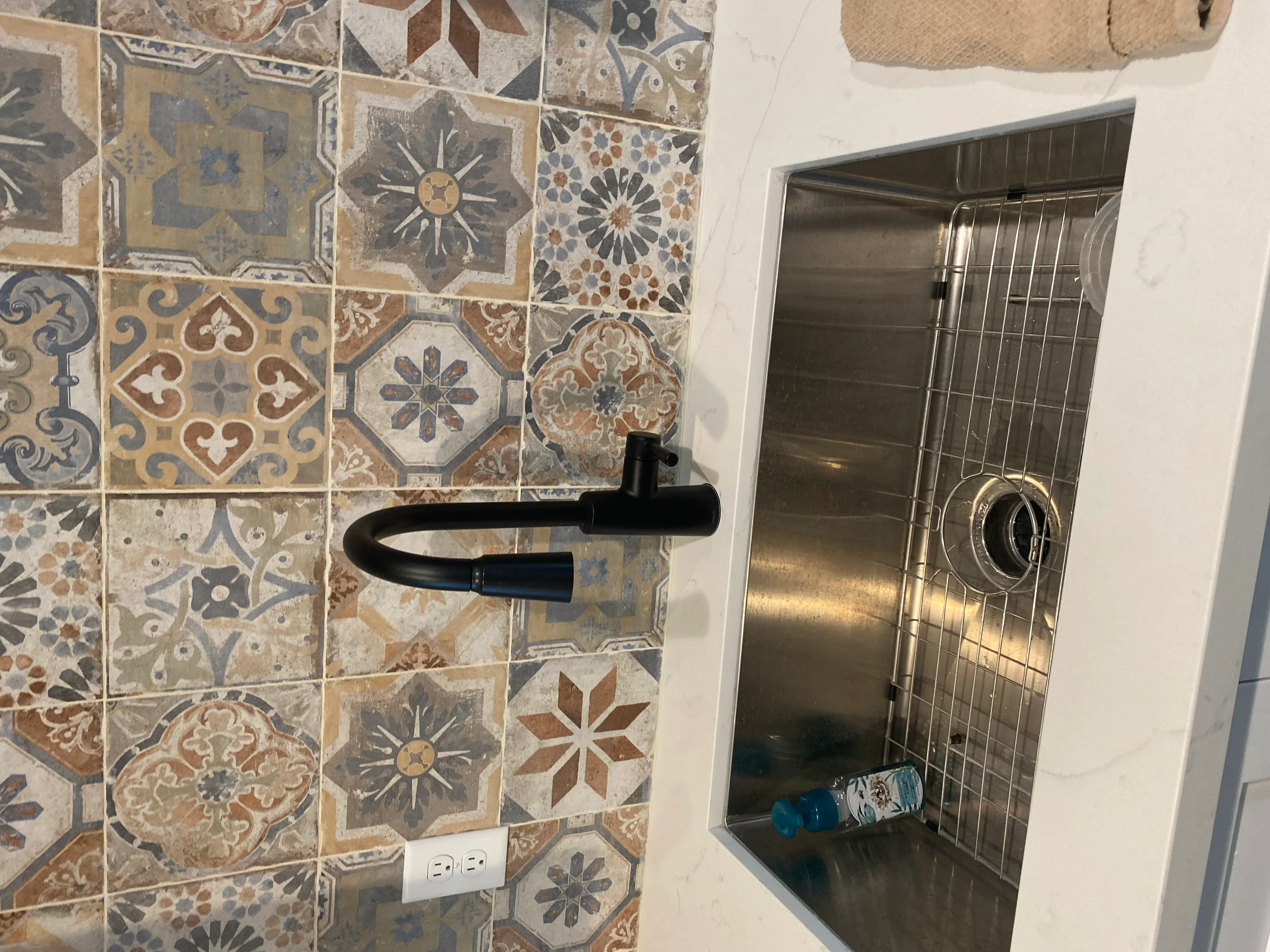 Decorative patterned ceramic tile shower wall with stainless steel recessed niche and black towel bar