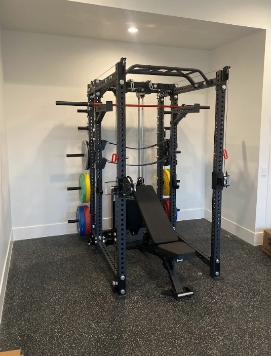 Black steel Smith machine with weight plates and bench in finished basement gym space