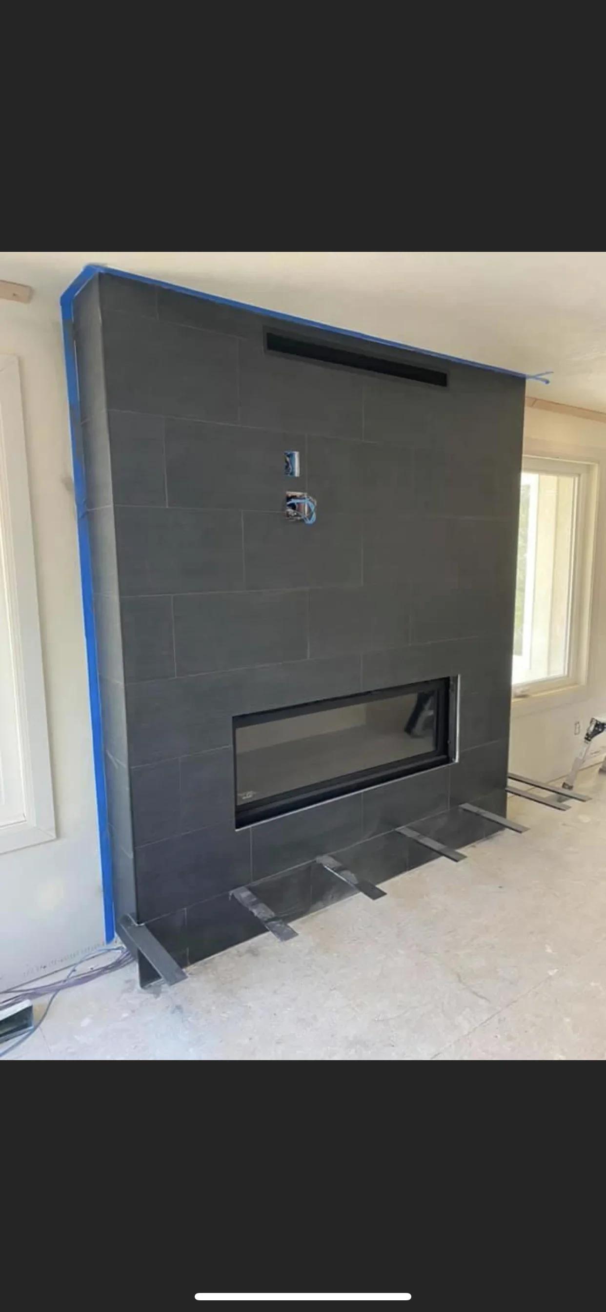 Dark gray tile fireplace surround with linear gas insert and chrome fixtures