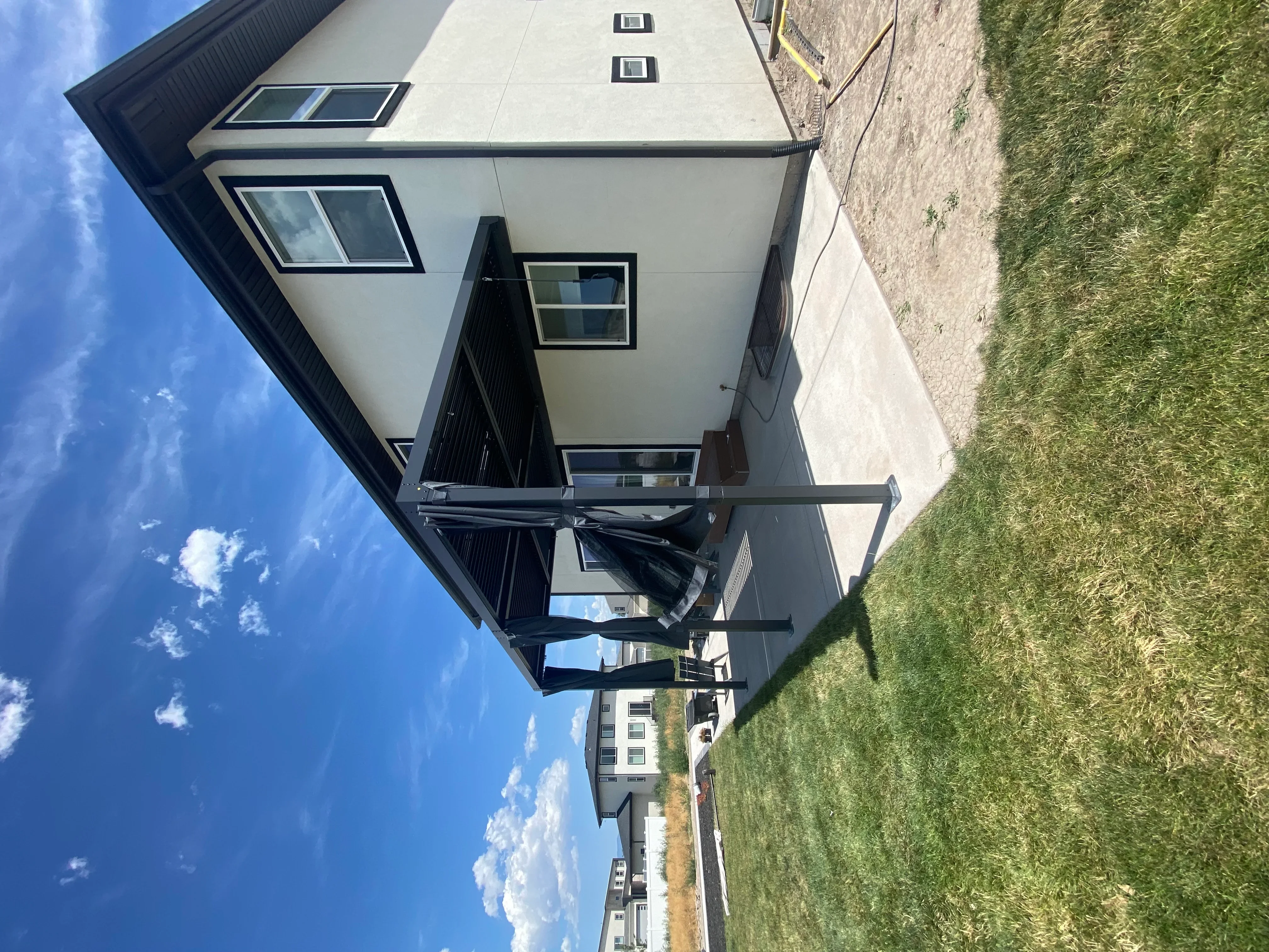 Modern home exterior with light gray fiber cement siding, black trim, and new double-hung windows