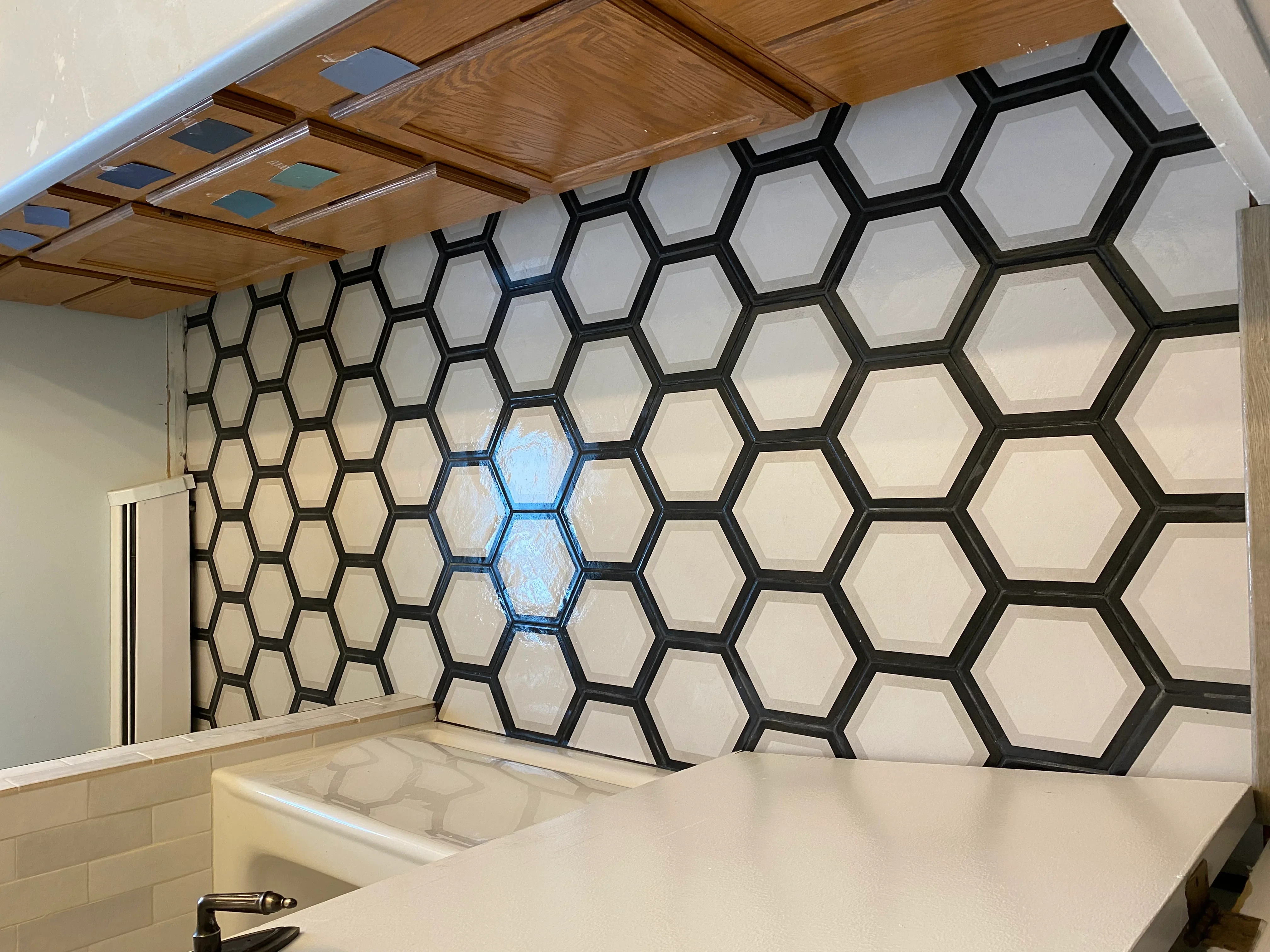 Black and white hexagonal tile backsplash with blue accent tiles above kitchen counter