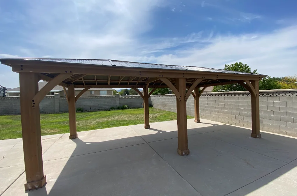 Wooden pergola with timber posts and slatted roof over concrete patio