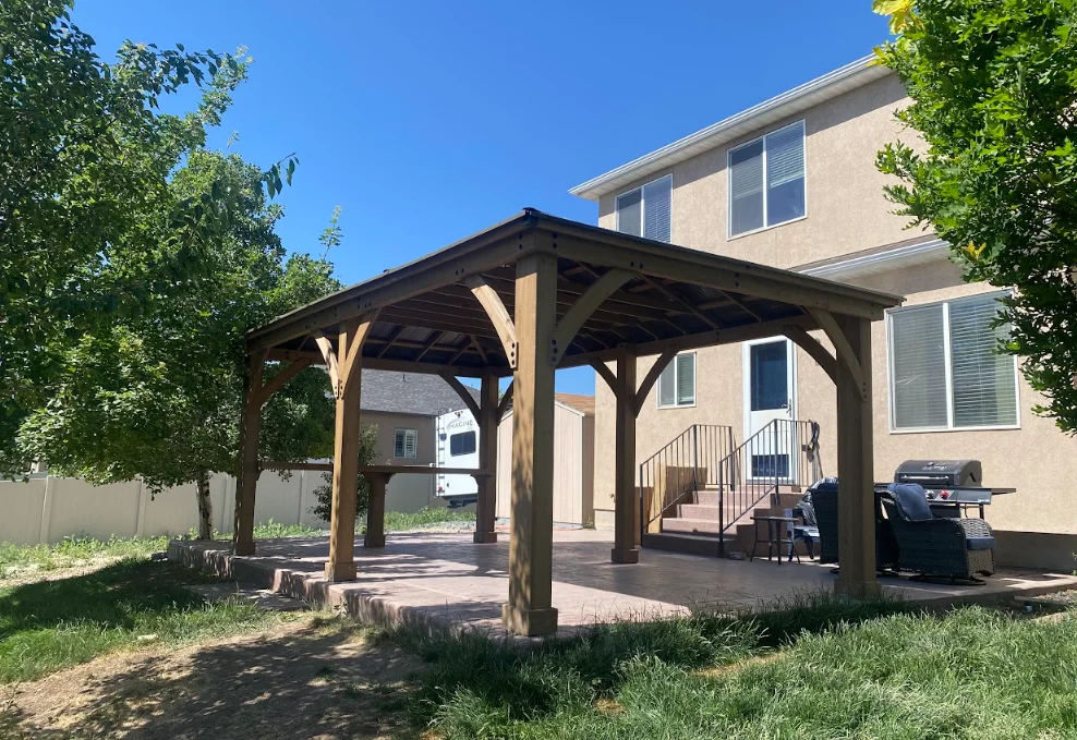 Wooden pergola with timber frame posts and beams over paver patio