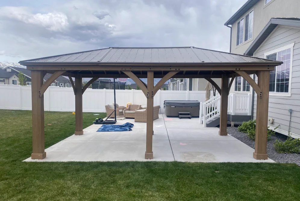 Wooden pergola with metal roof over concrete patio, timber frame construction